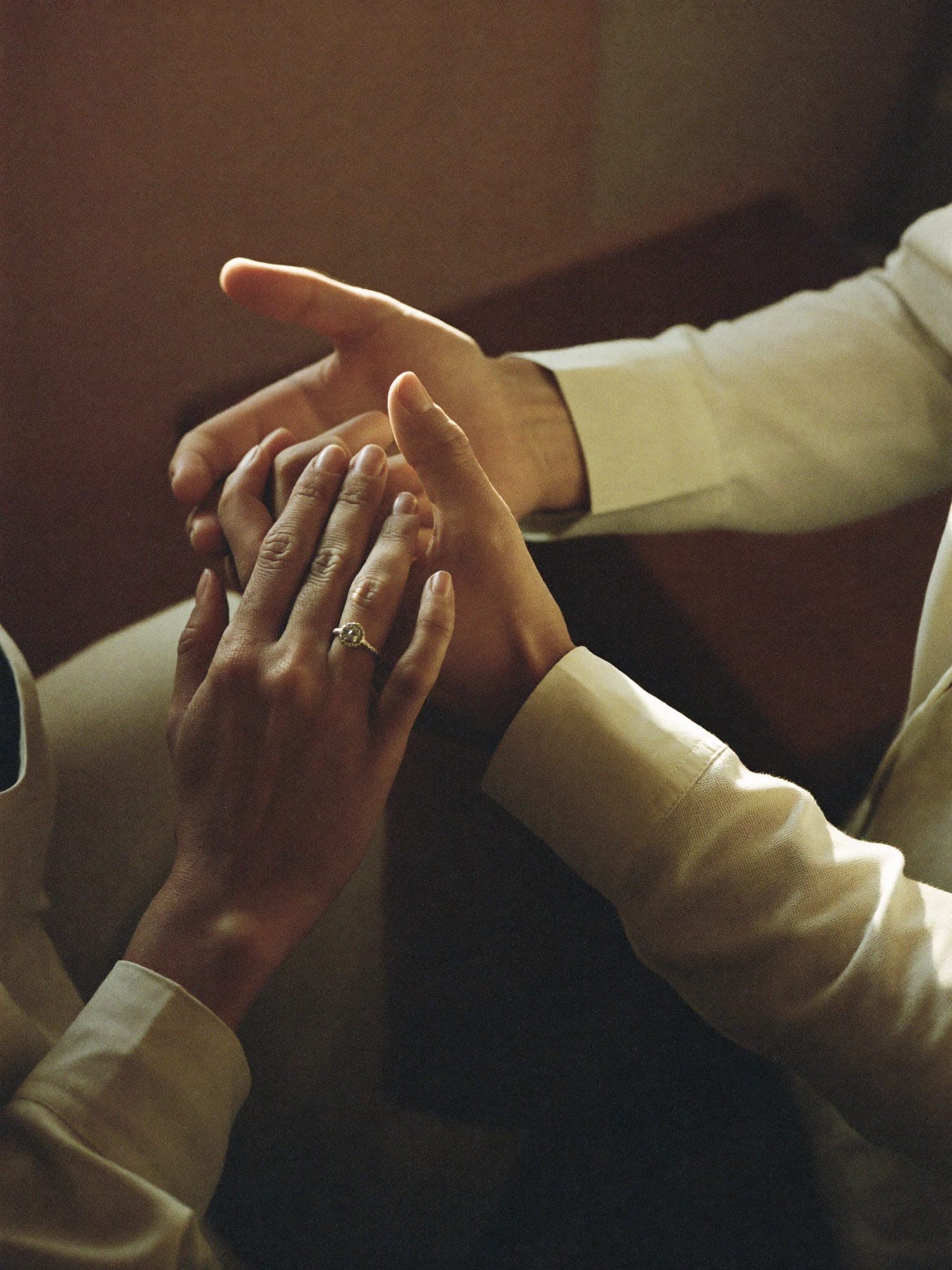 Manos de una pareja entrelazadas mostrando el anillo de compromiso